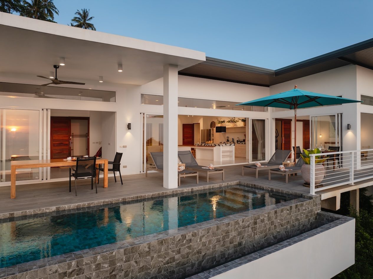 Kacha exterior at sunset — pool, deck, and west-facing view